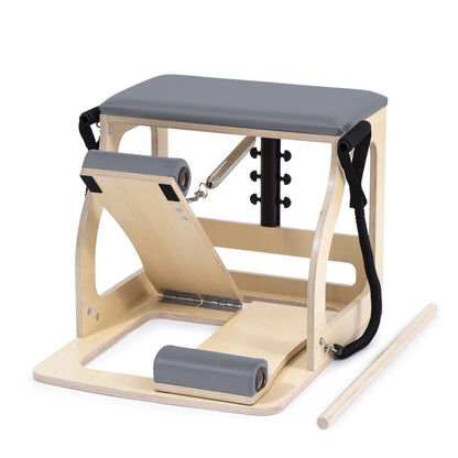 Pilates reformer machine with wooden frame and gray cushion on a white background